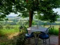 Preview: Rustic dream home in Italy – 3,000 m² surrounded by greenery with panoramic views, garden terrace with table under shady trees.
