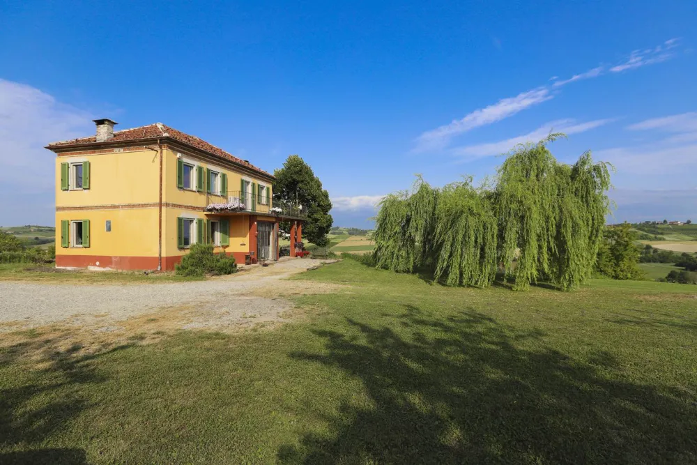 Preview: Rustic dream home in Italy – 3,000 m² surrounded by greenery with panoramic views Preview: Rustic dream home in Italy – 3,000 m² surrounded by greenery with panoramic views, farmhouse with green shutters and willow tree.