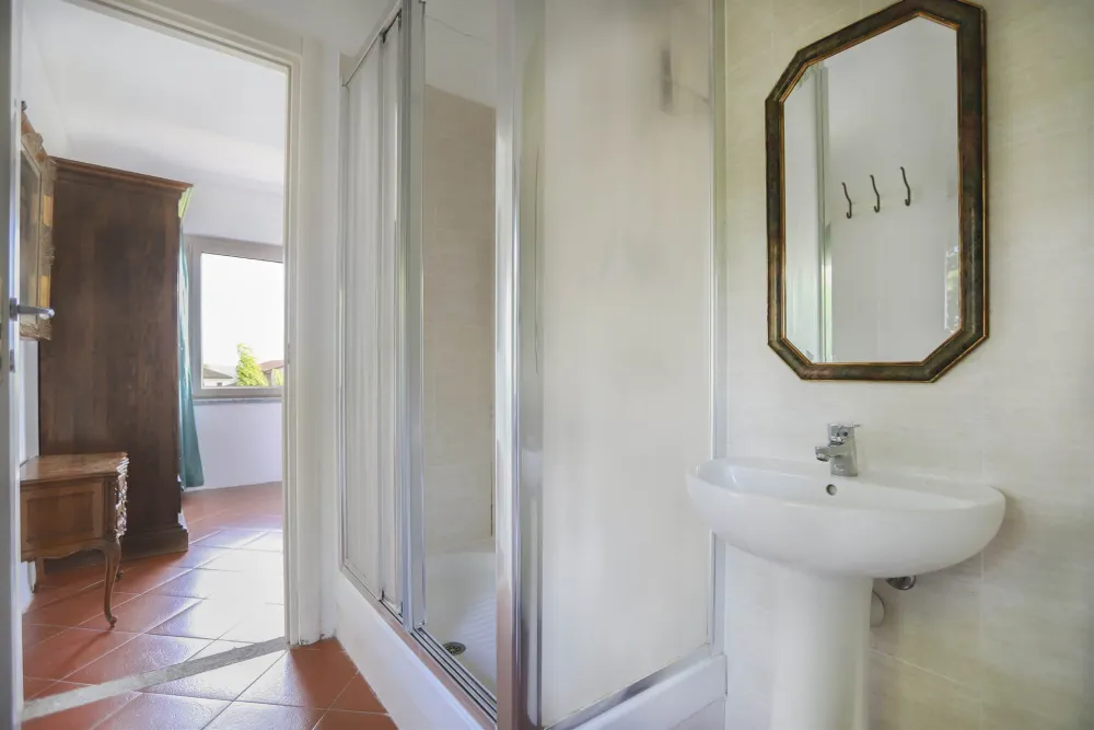 Preview: Rustic dream home in Italy – 3,000 m² surrounded by greenery with panoramic views Preview: Rustic dream home in Italy – 3,000 m² surrounded by greenery with panoramic views, bathroom with shower, sink and mirror.