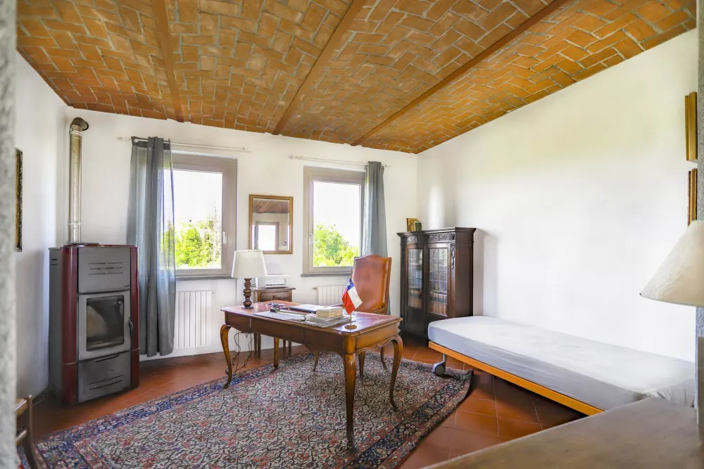 Rustic dream home in Italy – 3,000 m² surrounded by greenery with panoramic views, study with stove and wooden cabinet.