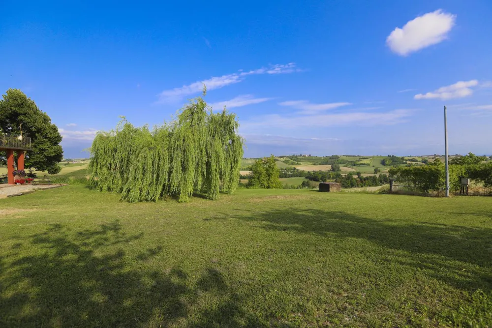 Rustic dream home in Italy – 3,000 m² surrounded by greenery with panoramic views, garden with willow tree and panoramic view.