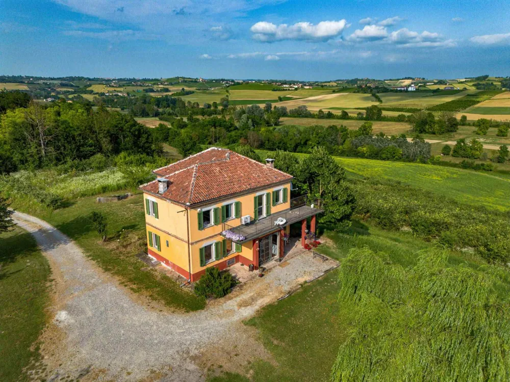 Rustic dream home in Italy – 3,000 m² surrounded by greenery with panoramic views, drone shot of the house and surrounding countryside.
