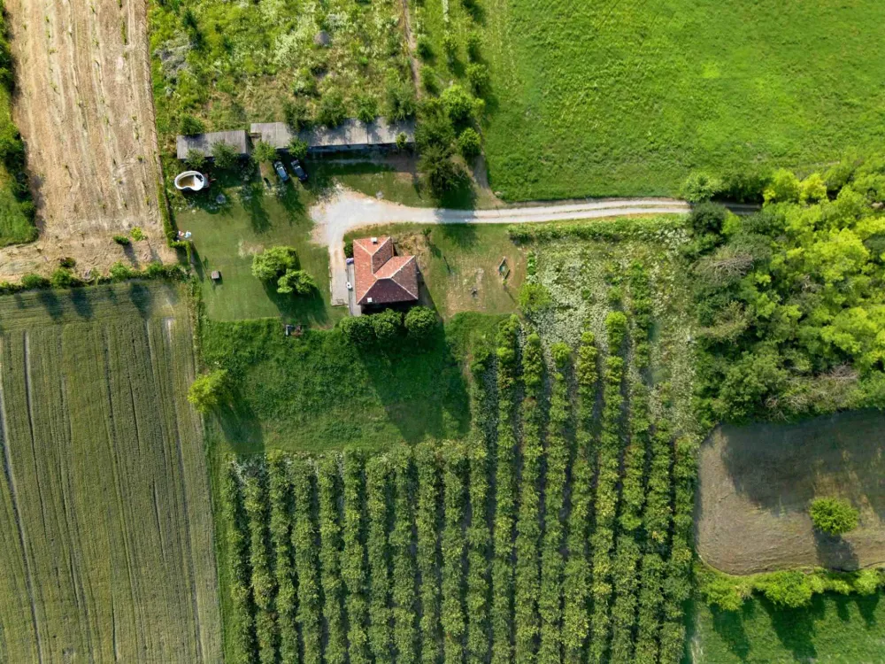 Rustic dream home in Italy – 3,000 m² surrounded by greenery with panoramic views, top-down aerial shot of the house and fields.