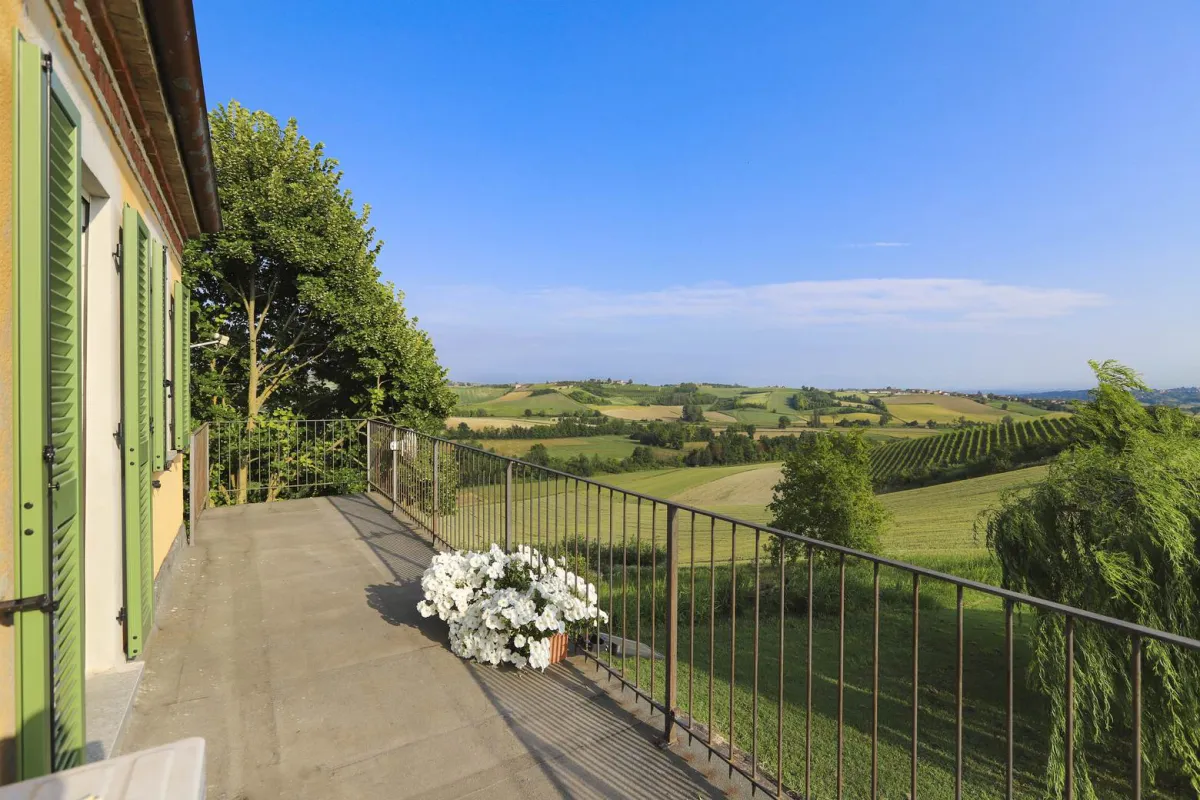 Rustic dream home in Italy – 3,000 m² surrounded by greenery with panoramic views, balcony overlooking rolling hills.