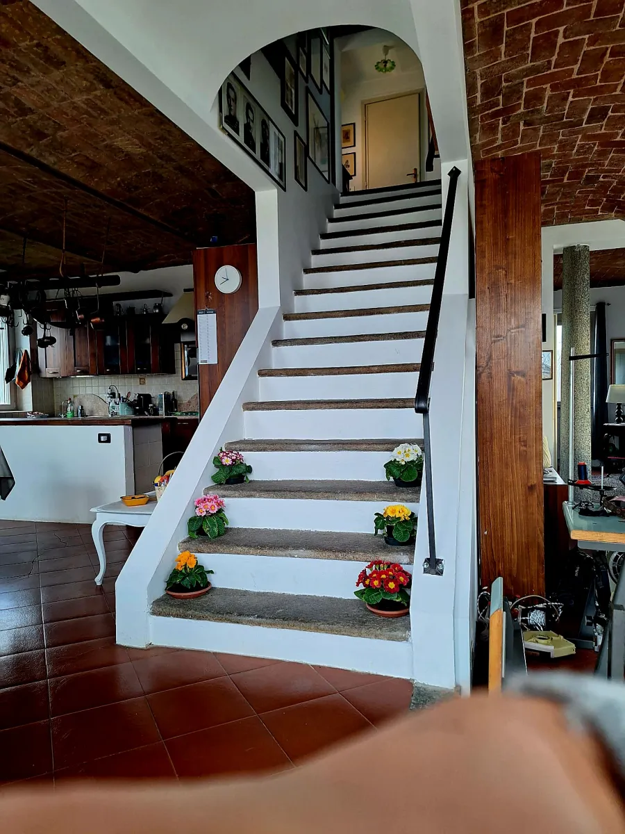 Rustic dream home in Italy – 3,000 m² surrounded by greenery with panoramic views, staircase decorated with colorful flowers.