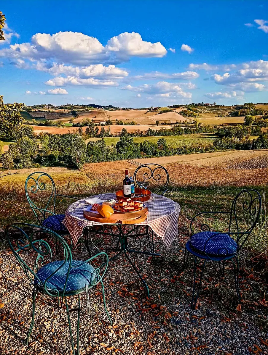 Rustic dream home in Italy – 3,000 m² surrounded by greenery with panoramic views, outdoor table with wine, cheese and cold cuts.