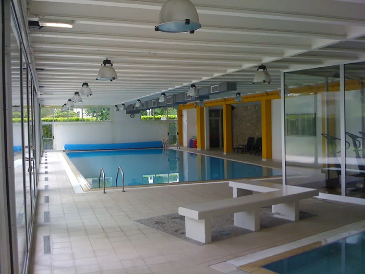 Piscina interna riscaldata del residence con zona relax e vetrate panoramiche